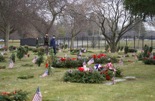 Lalor and his son walk through the Veterans&#39; section of the cemetery after placing wreaths.