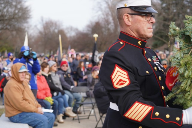 A Marine carries a commemorative wreath to honor fallen Marines.