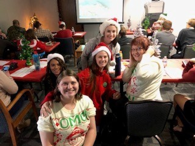 Christine Garcia, U.S. Army Combat Capabilities Development Command, poses for a photo with North American Aerospace Defense Command Tracks Santa volunteers Dec. 24, 2019, in the NORAD Tracks Santa call center at Peterson Space Force Base, Colo. Garcia has been volunteering with NORAD Tracks Santa for 10 years. 