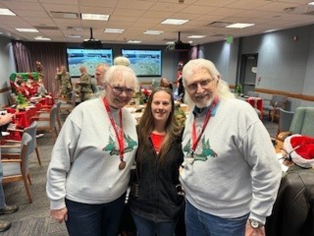 Christine Garcia, U.S. Army Combat Capabilities Development Command, poses for a photo with North American Aerospace Defense Command Tracks Santa volunteers Dec. 24, 2022, in the NORAD Tracks Santa call center at Peterson Space Force Base, Colo. Garcia has been volunteering with NORAD Tracks Santa for 10 years. 