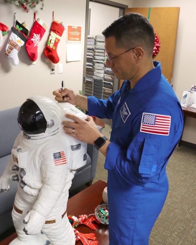 Army astronaut Col. (Dr.) Frank Rubio signs a command astronaut display during a visit to the Space and Missile Defense Command headquarters Dec. 13. He visited with several staff sections and gave a presentation on his time aboard the International Space Station. 