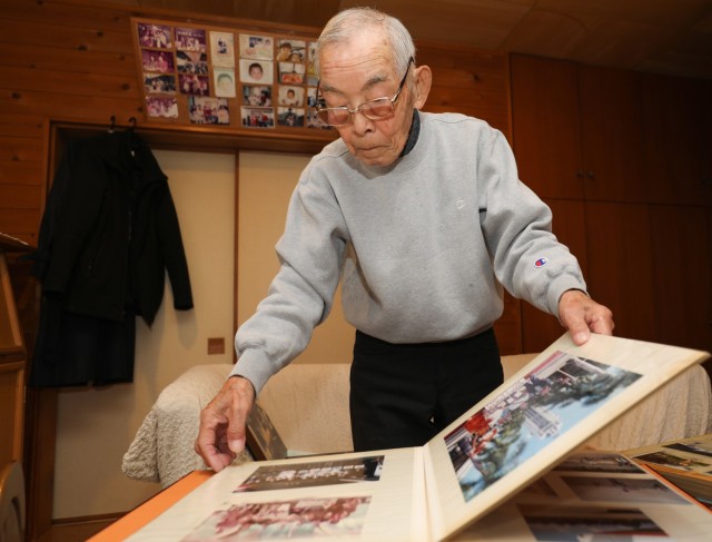 Tsuneo Yamagishi, 95, looks through one of his photo albums while at his home in Sagamihara, Japan, Dec.  5, 2023. Yamagishi, who previously served in the Japanese Imperial Navy, eventually worked more than 50 years at U.S. Army installations following World War II.