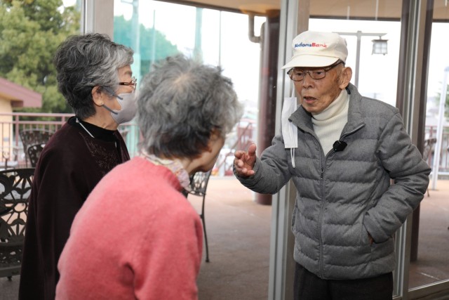 Tsuneo Yamagishi, right, speaks with some old friends while visiting the Camp Zama Golf Course in Japan, Dec. 15, 2023. Yamagishi, 95, worked more than 50 years at U.S. Army installations following World War II.