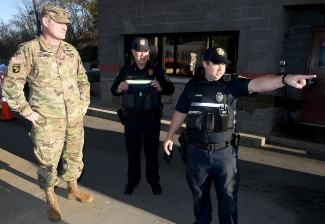 Colton Caler, a security officer at Redstone Arsenal, points Garrison Commander Col. Brian Cozine in the direction of an incident Dec. 12 at Gate 1.  
 