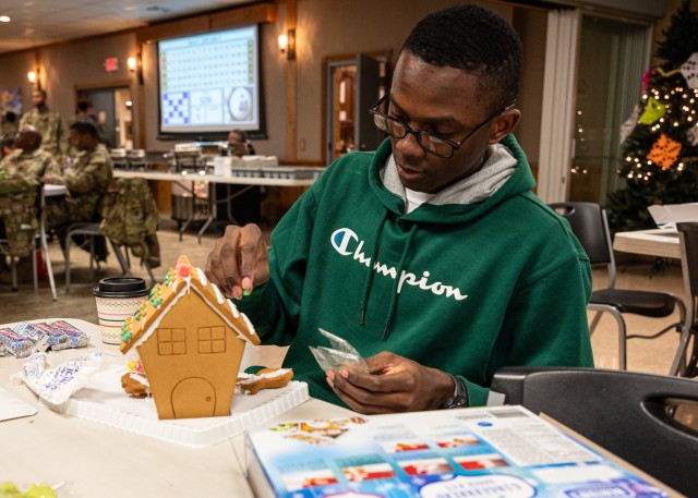 Air Force Airman 1st Class Darron Nichols, with Fort Leonard Wood’s 368th Training Squadron, builds and decorates a gingerbread house on Dec. 21 at an event in Rolla, Missouri, where service members had opportunities to play various games,...