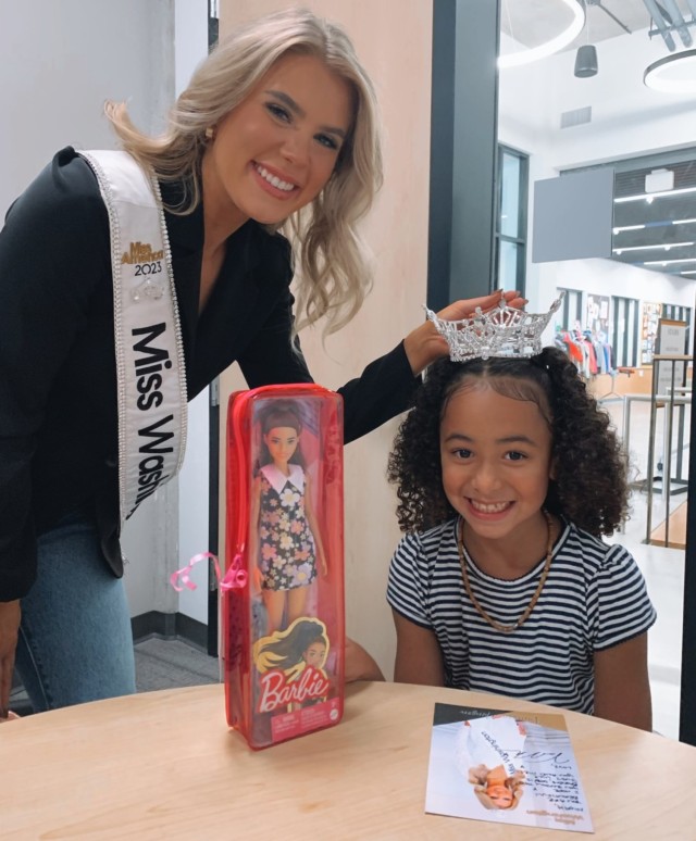Sgt. Vanessa Munson poses with a student after bringing hearing-impaired Barbie dolls to their school. Munson went through eight surgeries in her ear which led to hearing loss. 