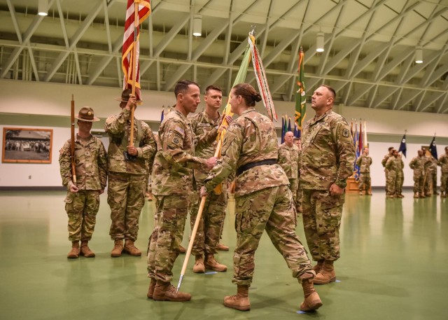 Incoming 14th Military Police Brigade Commander Col. John Copeland accepts the unit guidon from U.S. Army Military Police School Commandant Brig. Gen. Sarah Albrycht, during a change-of-command ceremony July 14 in Nutter Field House, where Fort Leonard Wood bid the outgoing commander Col. Kirk Whittenberger farewell and welcomed Copeland. 