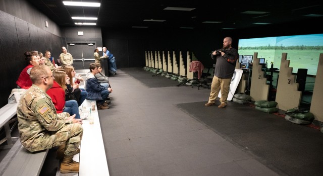 Chris Hart, Engagement Skills Trainer operation technician, shows Summersville High School students how to use the M4 rifle attachment, before letting them take aim at the screen during a field trip to Fort Leonard Wood on Jan. 8.