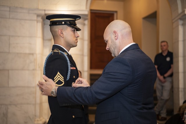 Bryan Campagna pins the Guard, Tomb of the Unknown Soldier Identification Badge onto his son, U.S. Army Staff Sgt. Isaiah Jasso-Campagna, during a ceremony in the Lower Memorial Amphitheater Chapel at Arlington National Cemetery, Arlington, Va.,...