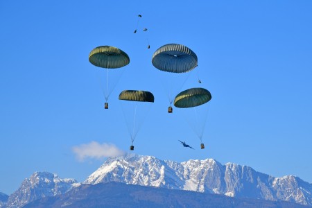 U.S. Army paratroopers assigned to 1st Battalion, 503rd Parachute Infantry Regiment, 173rd Airborne Brigade, release heavy drop packages with a U.S. Air Force 86th Air Wing C-130 Hercules aircraft onto Frida Drop Zone at Pordenone, Italy on Jan. 9, 2024.