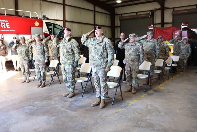 Attendees at the Fort Johnson North Fort Fire Station ribbon cutting ceremony salute during the national anthem.