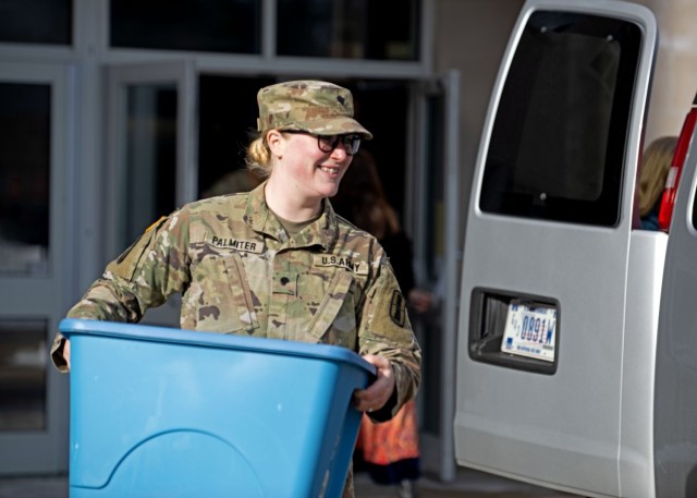 Spc. Olivia Palmiter, international support specialist with Joint Force Headquarters, New Hampshire Army National Guard, helps load donated books into a cargo van Jan. 17, 2024, at Bow High School in Bow, New Hampshire. New Hampshire Guardsmen collected 33 boxes of donated books to be delivered to students at Pedro Gomes High School in Cabo Verde as early as next month. (U.S. Air National Guard photo by Master Sgt. Charles Johnston)