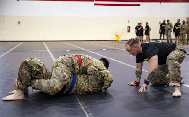 U.S. 1st Lt. Bobby Heald, an infantry officer assigned to Headquarters and Headquarters Company, 1st Battalion, 16th Infantry Regiment, 1st Armored Brigade Combat Team, 1st Infantry Division (red belt), grapples Chief Warrant Officer 2 A. James...