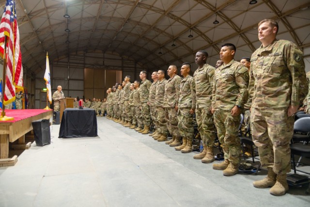 Command Sgt. Maj. Curtis Moss, the senior enlisted advisor to the commander of the 369th Sustainment Brigade, Task Force Hellfighter, leads the Charge of the Non-Commissioned Officer during an NCO induction ceremony held at Camp Buehring, Kuwait, Feb. 18, 2023.