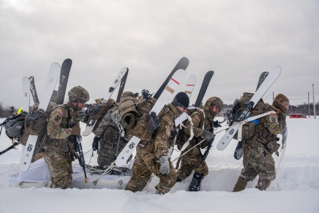 The team from Headquarters and Headquarters Company, 2nd Battalion, 30th Infantry Regiment, 3rd Brigade Combat Team, 10th Mountain Division work together to drag an Ahkio sled through Division Hill landing zone during the D-Series XXIV winter challenge on Fort Drum, NY, Jan. 19, 2024. D-Series references the culminating exercise the original 10th Mountain Division Soldiers went through from March-April in 1944, to prepare for combat in the mountains of Italy. (U.S. Army photo by Spc. Salvador Castro)