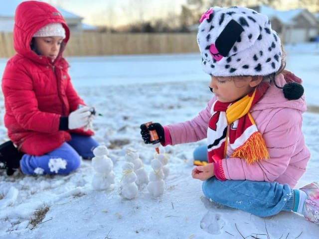 Roselani, left, and Harmony Krumm build miniature snowmen during the winter weather that froze the Tennessee Valley Jan. 15-18. 
