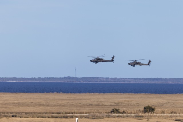 U.S. Army AH-64E Apache helicopters assigned to 82nd Aviation Regiment, 82nd Airborne Division of Fort Liberty, North Carolina, fly over the Bombing Target 11 range on Piney Island, North Carolina, during a forward arming and refueling point exercise, Jan. 22, 2024. Soldiers used Marine Corps Air Station Cherry Point’s authentic training environment to refine tactical proficiency and adaptability. (U.S. Marine Corps photo by Cpl. Noah Braswell)