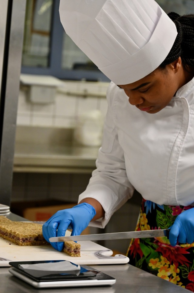 Staff Sgt. Symone Abreu, a member of the U.S. Army Culinary Arts Team (USACAT), carefully portions a dish during a training session at the Originals Dining Facility on Panzer Kaserne, U.S. Army Garrison Stuttgart, Jan. 24, 2024.