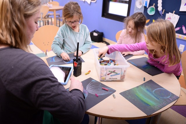 Child and Youth Program Assistant Maci Forrey draws nebulas and galaxies with pastels on black paper with 7-year-olds Raegan Terwilliger, Hazel Knight and Olivia Lynch Jan. 29 in the Osage School-Age Center art room at Fort Leavenworth, Kan. Photo...
