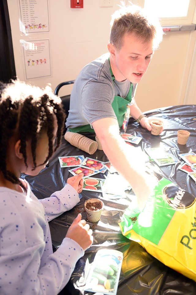 Child and Youth Program Assistant Peter Anderson vegetable seeds with 8-year-old Melany Mullings Jan. 29 in the Osage School-Age Center science room at Fort Leavenworth, Kan. Photo by Prudence Siebert/Fort Leavenworth Lamp
