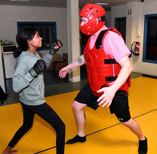 Staff Sgt. Nicholas Klein is suited up in protective gear while a student attacks him during a self-defense class. 