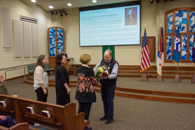 Dr. Jack Kem, Dean of Academics, Command and General Staff College, presents bouquets of flowers to his wife and two daughters during his retirement ceremony at the Frontier Chapel on Fort Leavenworth