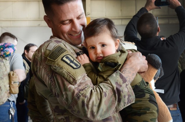 Sgt. 1st Class Jeff Stainsby, A Battery, 182nd Field Artillery, Michigan National Guard, holds his daughter, Clair, for the first time at the unit’s welcome home ceremony in Detroit, Mich, Feb. 8, 2024. (U.S. Army photo by Master Sgt. Helen Miller)