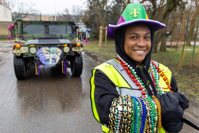 A soldier assigned to the  773rd Military Police Battalion senior stands in front of her decorated humvee during the very first Mardi Gras parade at Camp Kosciuszko in Poznan, Poland, Feb. 9, 2024. The 773rd MP Bn., a Louisiana Guard Unit based out of Pineville, has spent the past year providing security and law enforcement capabilities to U.S. Army Garrison Poland.