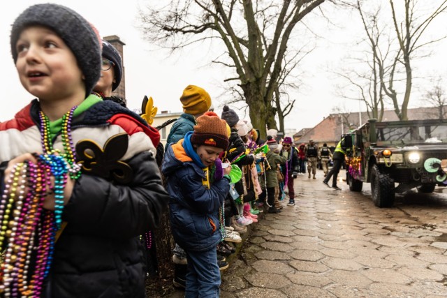 Polish elementary school students collect beads during a Mardi Gras parade across Camp Kosciuszko in Poznan, Poland, Feb. 9, 2024. The event was hosted by the 773rd Military Police Battalion, a Louisiana Guard Unit based out of Pineville. The unit has spent the past year providing security and law enforcement capabilities to U.S. Army Garrison Poland.