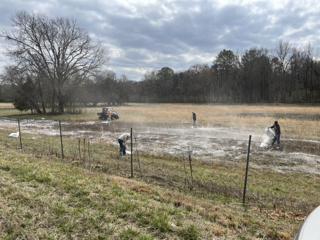 Crews treat an area flooded by a sewage line that ruptured Thursday.