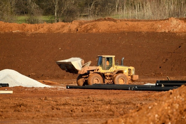 A front-end loader moves gravel near Goss Road. Crews are working to prepare land that is part of a 60-acre site in the secured Gateway development.