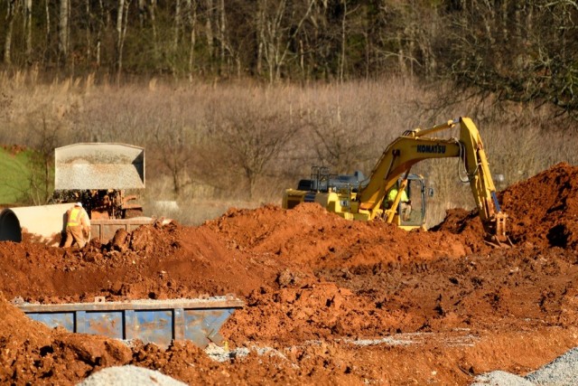 An excavator works to clear a portion of land in the second phase of the secured part of Redstone Gateway near Goss Road.