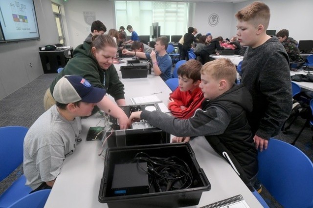 Linnie Findlay, a cyber camp crew trainer, shows Aiden Gould, 11, and his twin, Elliott, of Rainbow City, and Chris Johnson, 12, of Tuscaloosa, the parts of a computer during U.S. Cyber Academy at the U.S. Space & Rocket Center on Friday.