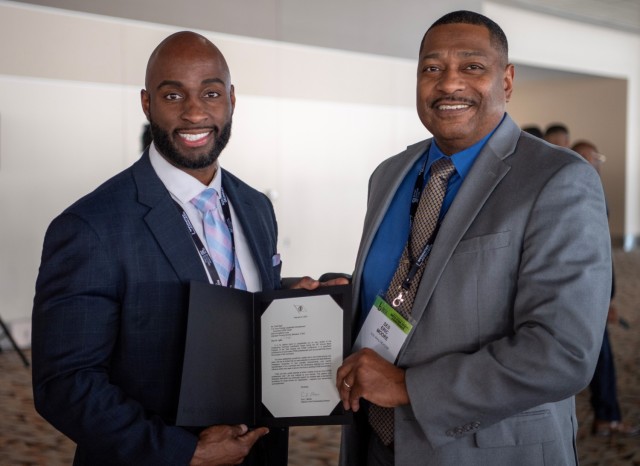 Dr. Eric Moore, U.S. Army Combat Capabilities Development Command, or DEVCOM, Deputy to the Commanding General, right, and Chad Nash, DEVCOM Command, Control, Communications, Computers, Cyber, Intelligence, Surveillance and Reconnaissance Center, left, pose for a photo Feb. 17, 2024, at the Baltimore Convention Center in Baltimore, Maryland. Mims received the Black Engineer of the Year Awards in Science, Technology, Engineering and Math Outstanding Technical Contribution award. 