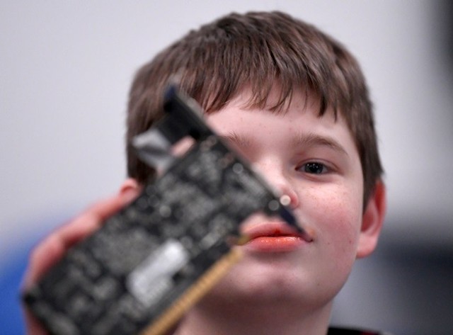 Evan Manning, 13, of Jasper, scrutinizes parts of a computer during U.S. Cyber Academy at the U.S. Space & Rocket Center.