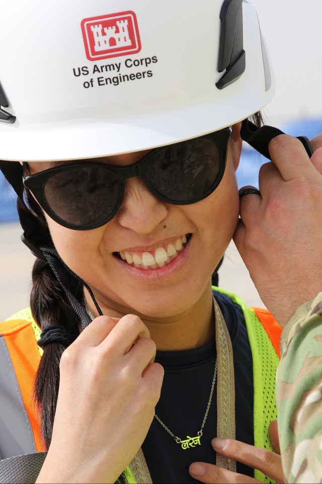 TAM Employee gets help with helmet strap.