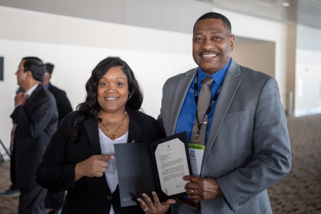 Dr. Eric Moore, U.S. Army Combat Capabilities Development Command, or DEVCOM, Deputy to the Commanding General, right, and Aisha Mims, DEVCOM Armaments Center, left, pose for a photo Feb. 17, 2024, at the Baltimore Convention Center in Baltimore, Maryland. Mims received the Black Engineer of the Year Awards in Science, Technology, Engineering and Math Modern-Day Technology Leader award. 