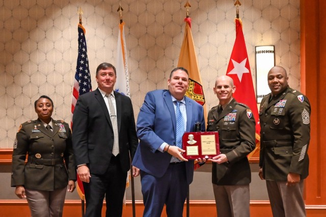 Richard “Rick” Helmrich, Business and Recreation Chief, Picatinny Arsenal’s Family and Morale, Welfare and Recreation (FMWR) Directorate (center) receives the James A. Carrol Jr. Award from Lt. Gen. Omar Jones, Commanding General, U.S. Army...