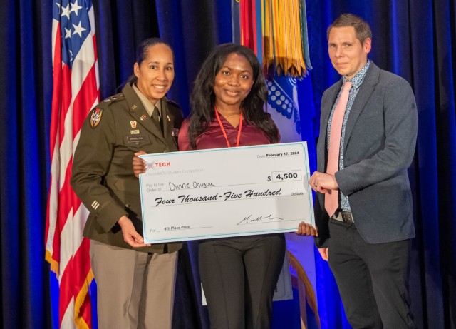 U.S. Army Lt. Col. Sherida Whindleton, deputy director of Army Prize Competitions and the Army Applied Small Business Innovation Research (SBIR) Program, and Dr. Matt Willis, director of Army Prize Competitions and the Army Applied SBIR Program, present Divine Ogugua with a check after winning 4th place in the xTechHBCU Student Competition at the Center of Influence event, hosted by the U.S. Army, during the 38th Annual Becoming Everything You Are, Science, Technology, Engineering and Mathematics (BEYA STEM) Conference, in Baltimore, Md., Feb. 17, 2024. (U.S. Army photo by Spc. Joseph Martin)
