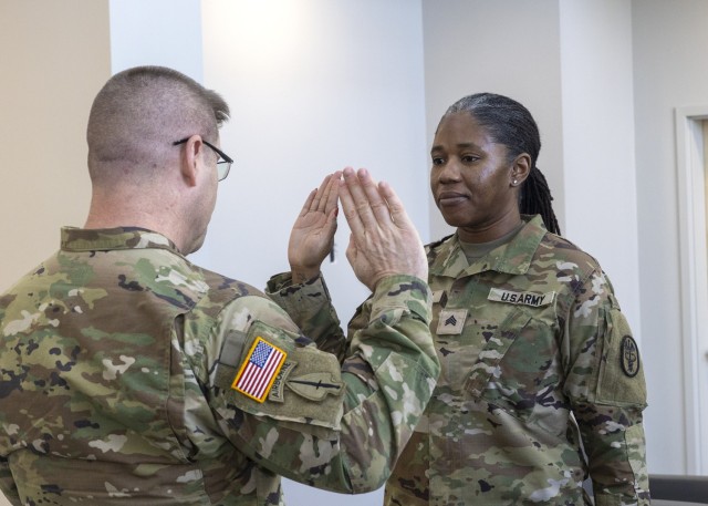 Maj. Gen. John T. Reim, Commanding General, Picatinny Arsenal and Joint Program Executive Officer Armaments & Ammunition (left) administers the oath of enlistment to Sgt. Faegist M. Adlam (right) during her reenlistment ceremony on Feb. 14.