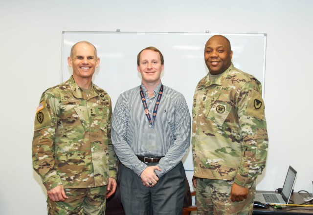 The commanding general of Installation Management Command, Lt. Gen. Omar J. Jones IV and Command Sgt. Maj. Jason R. Copeland present Daniel Cape, Supervisory General Engineer, with a coin on Feb. 28 for rewriting the BASOPS contract valued at $24...