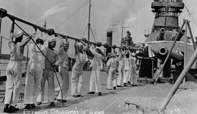 Crewmen clean the 14-inch guns of the USS Oklahoma’s forward turret.