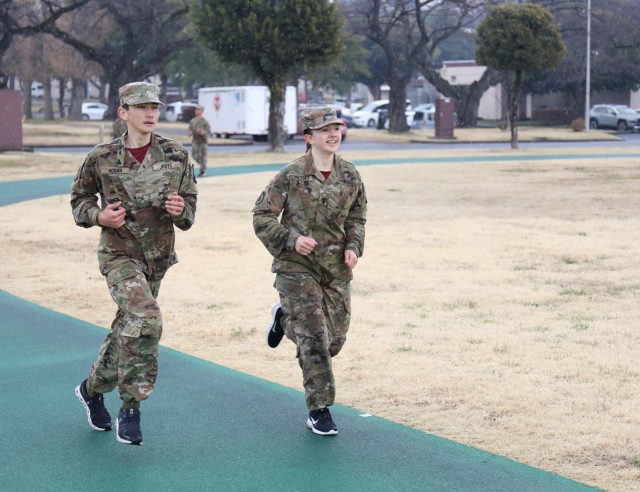 Cadets Noah Hogan, left, and Liliana Fennessey run along a track at Yano Sports Field as they conduct the Army Combat Fitness Test at Camp Zama, Japan, March 12, 2024. Soldiers from the 35th Combat Sustainment Support Battalion hosted a field day to familiarize Zama Middle High School cadets with some aspects of Army life.