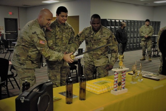 ABERDEEN PROVING GROUND, Md. – From left to right, Col. Phil Mundweil, APG Garrison commander, Private 1st Class, Jonathan Sierra, a SATCOM systems operator, 20th CBRNE Command, and Command Sgt. Maj. Paul Denson, APG Garrison command sergeant...