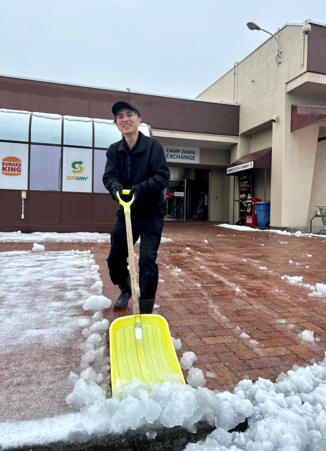 An Army and Air Force Exchange Service employee shovels snow in front of the Camp Zama food court Feb. 6, 2024, after heavy snow and slush covered the Kanto Plain. The community remained prepared for the event thanks to the hard work of a joint weather council.