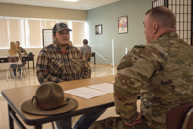 During a job interview and resume-writing lesson this week, Waynesville Career Center student Seth Richter talks welding on March 11 with Staff Sgt. Matthew Greene, a drill sergeant from Company B, 787th Military Police Battalion, who actually...