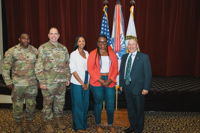 William Kidd, the director of the Installation Management Command-Training, presents a coin to Torlina Wofford of the Directorate of Human Resources on March 15 at the Landing on Fort Novosel.