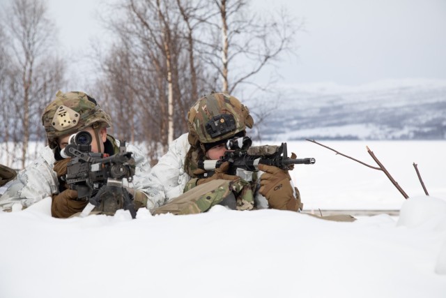 From left, U.S. Army Spc. Andrew Hayes and Spc. Christopher Bryant, infantrymen with Apache Company, 1st Battalion, 501st Parachute Infantry Regiment, 2nd Infantry Brigade Combat Team (Airborne), 11th Airborne Division, pull security on the shores of Lake Takvatnet following a static line jump during Arctic Shock 24 near Bardufoss, Norway, March 18, 2024. The jump follows an over-the-pole flight from Alaska, showcasing the 11th Airborne Division&#39;s capability to insert anywhere into the Arctic.