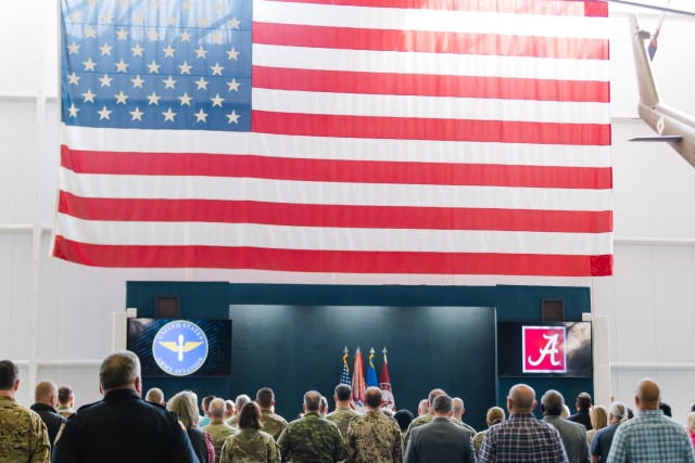A crowd stands during the Army Aviation song during an IGSA signing inside the Army Aviation Museum on Fort Novosel on March 20, 2024.