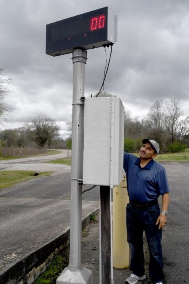 Edwin Lopez, chief of ammunition for the Logistics Readiness Center, shows how the scale works Saturday in front of building 8742.